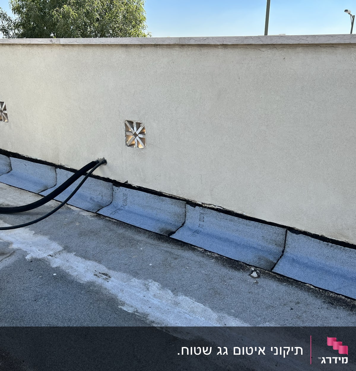 יריעות איטום כחולות על גג עם צינורות שחורים